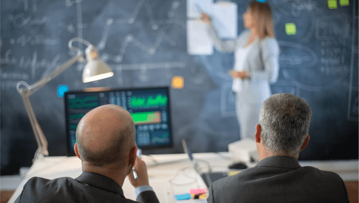 Reunião estratégica com análise de indicadores e gráficos, representando gestão moveleira orientada por KPIs em 2026